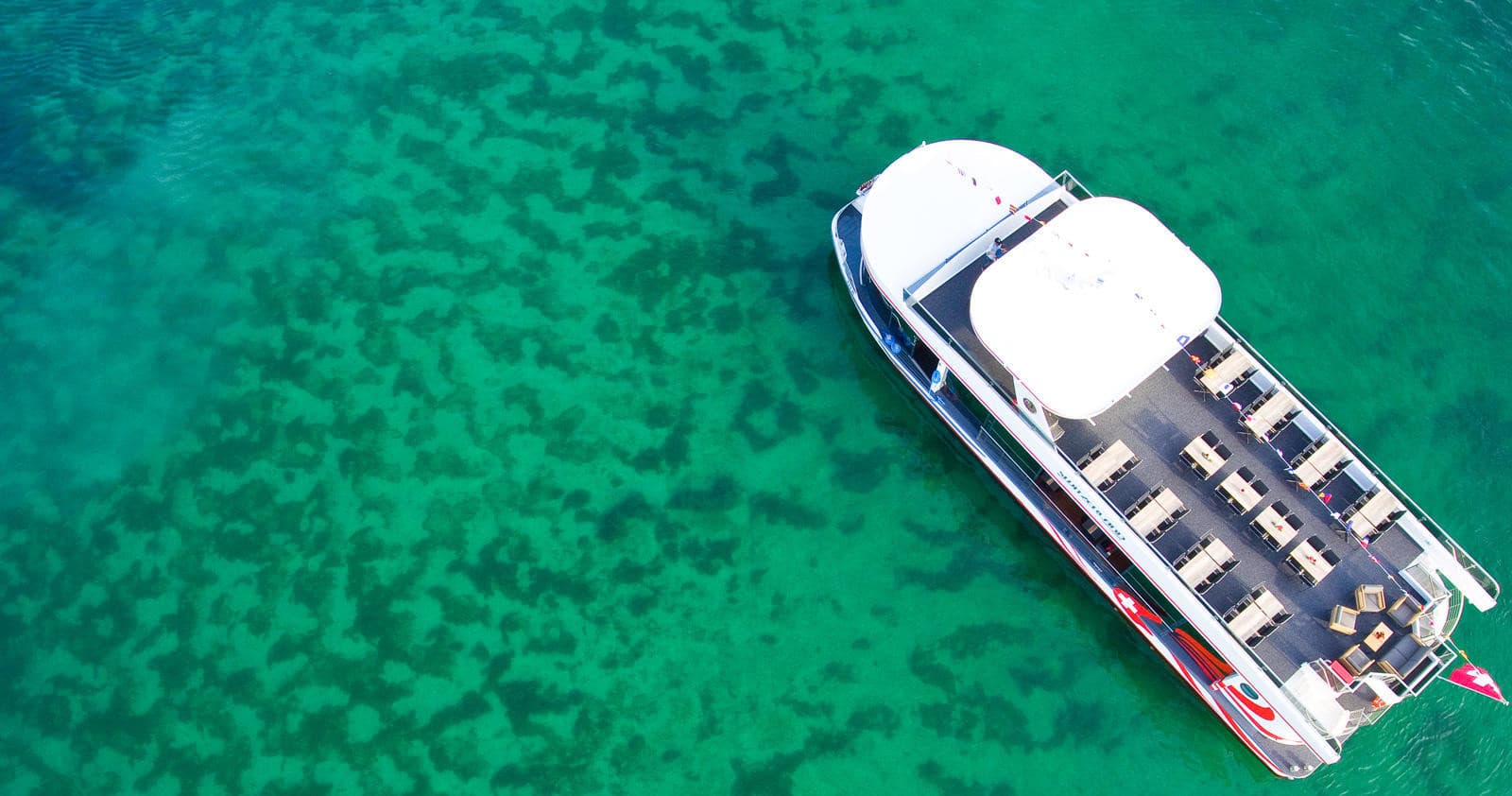 Aerial tour boat over clear turquoise sea near coral reef