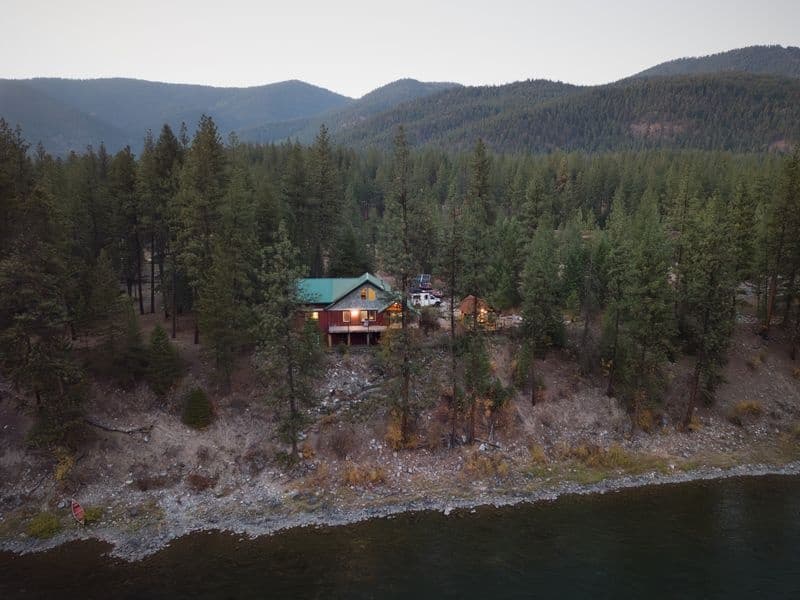 Lakeside cabin in pine forest by mountain lake, scenic retreat