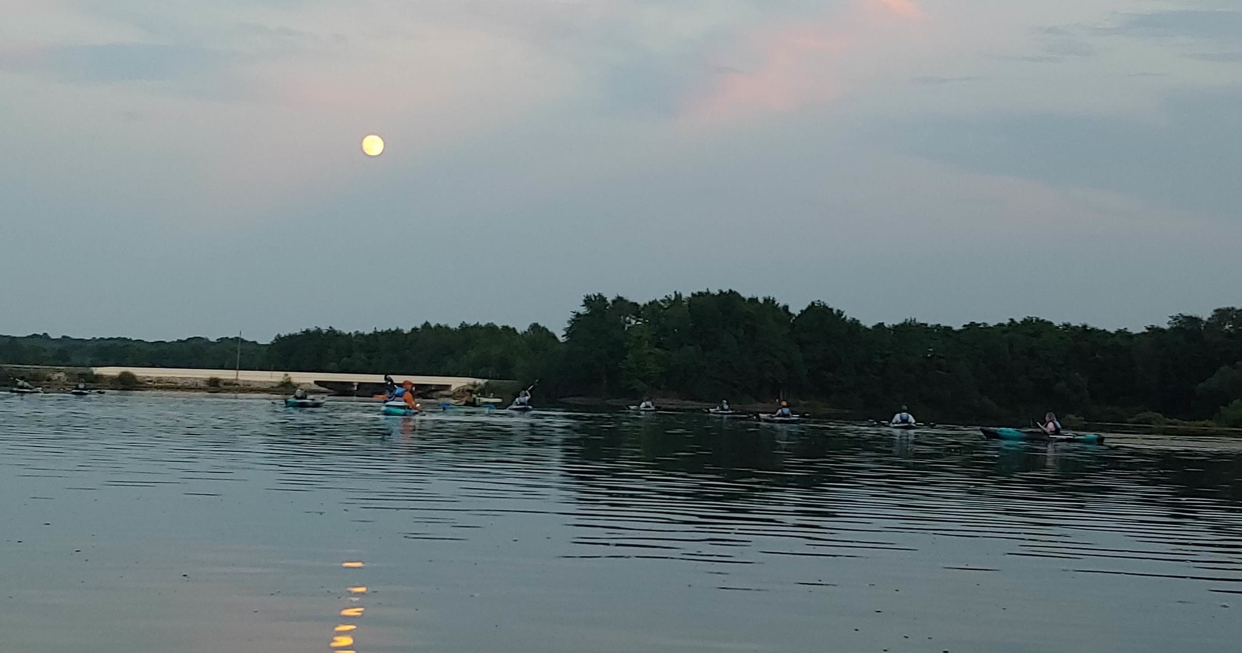 Wide lake vista with pastel sky and distant treeline at dusk