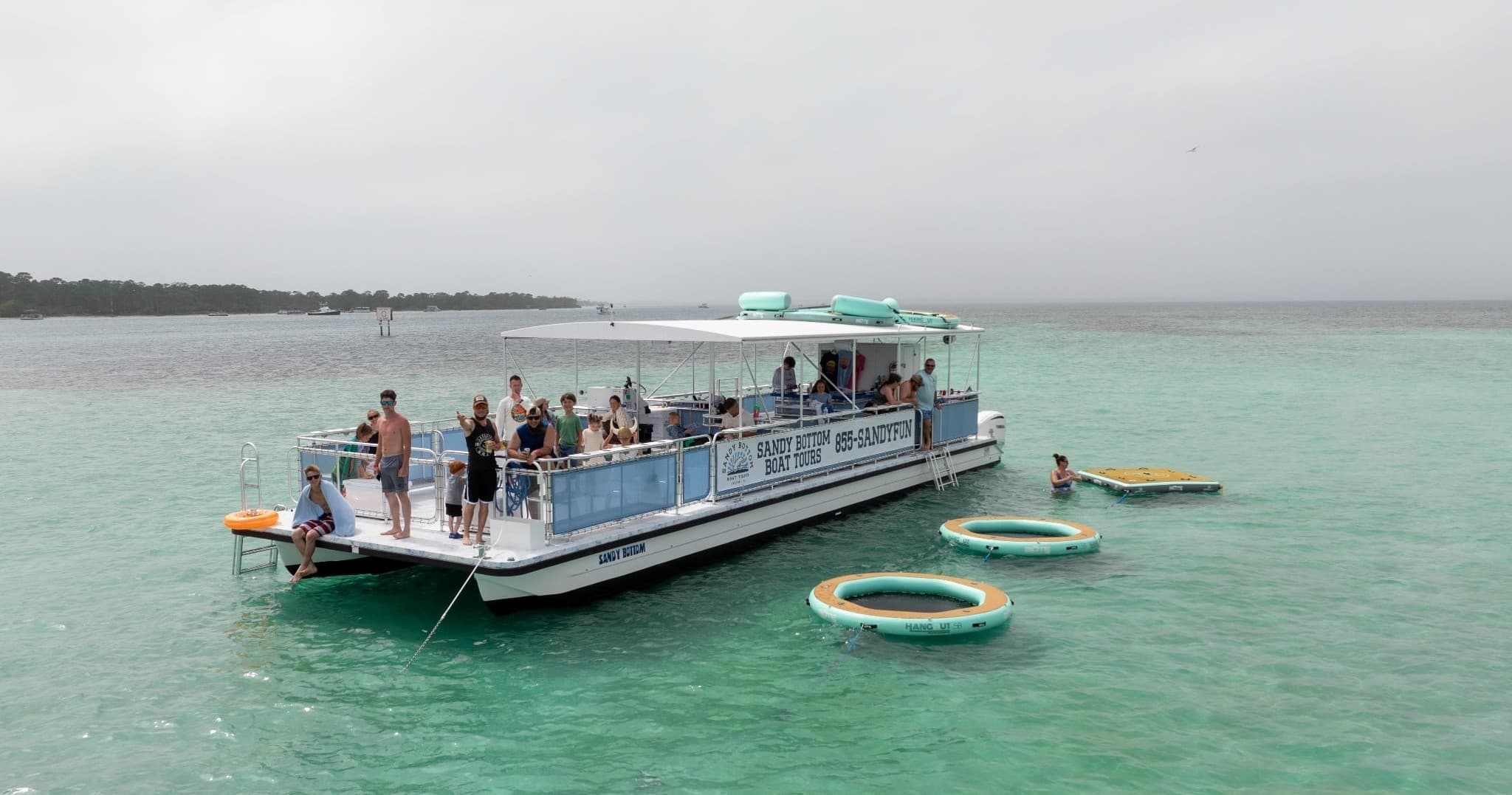 Party pontoon anchored in clear shallow turquoise sandbar