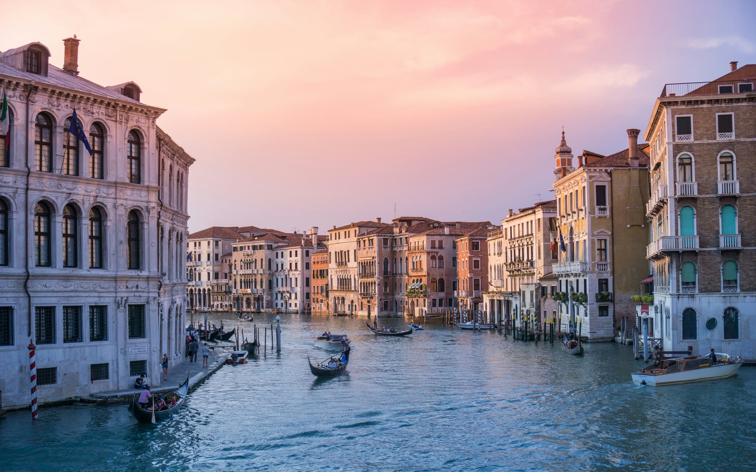 Venetian canal at dusk with historic buildings and gondolas