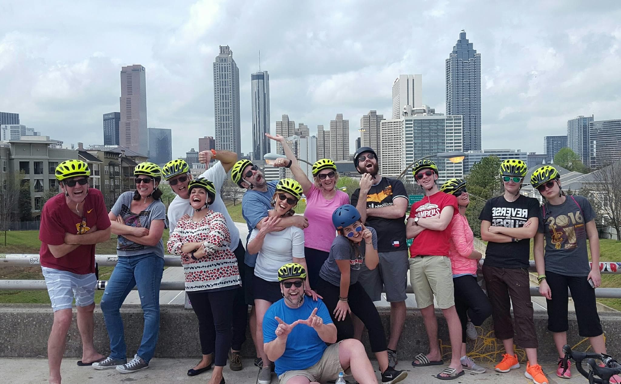Urban bike tour group on riverside path with skyline views