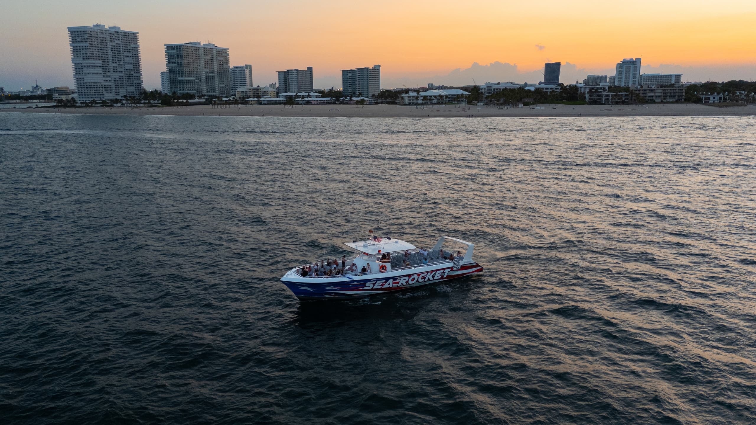 Powerboat cruising at sunset with Fort Lauderdale skyline backdrop