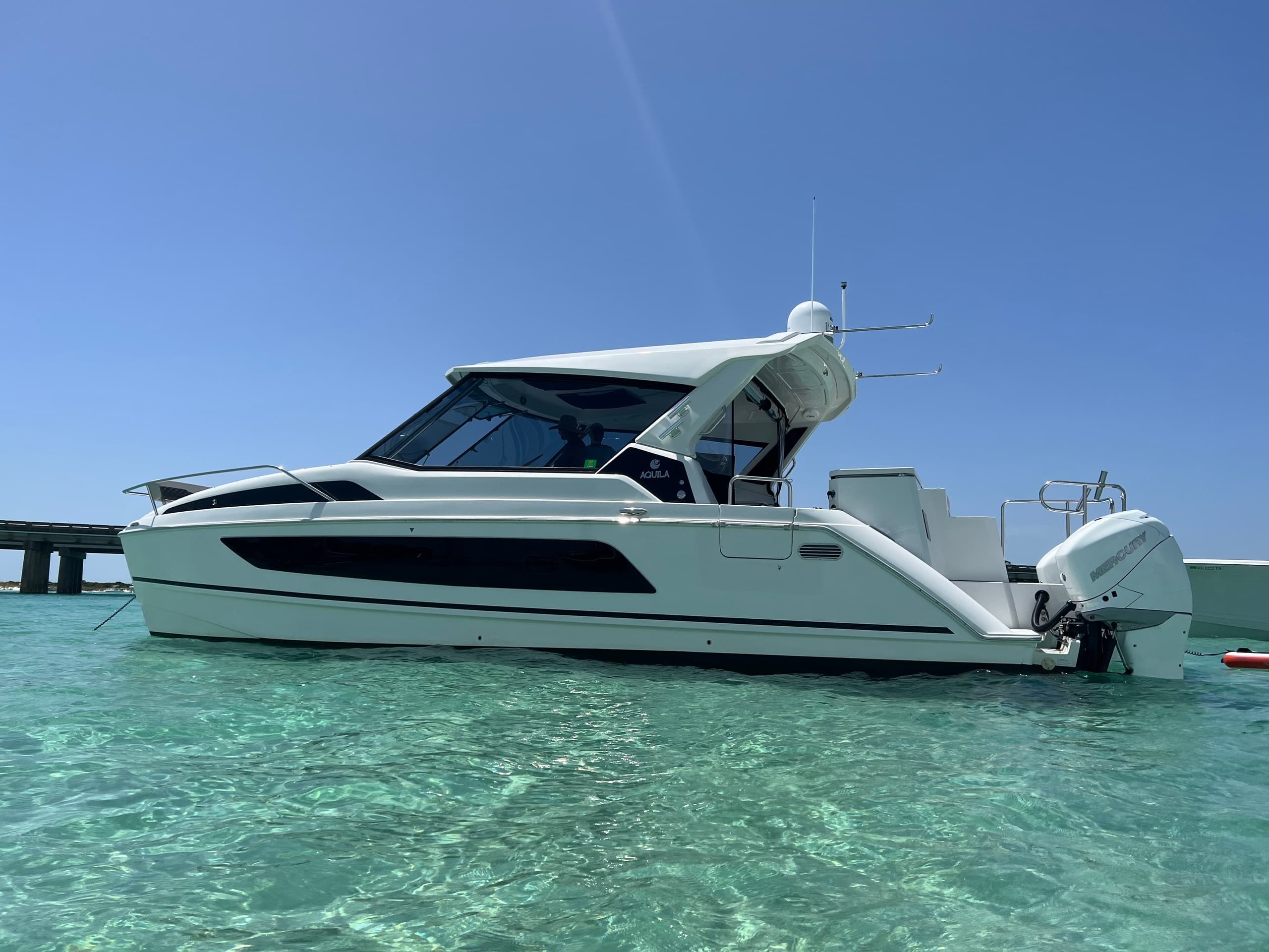 Sport cruiser anchored in turquoise shallow water at bay