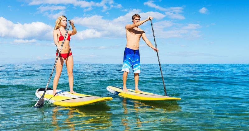Stand up paddleboarders on clear ocean water, coastal paddling