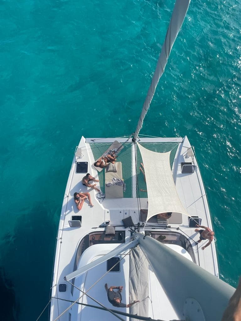 Aerial view of catamaran deck on clear turquoise tropical sea
