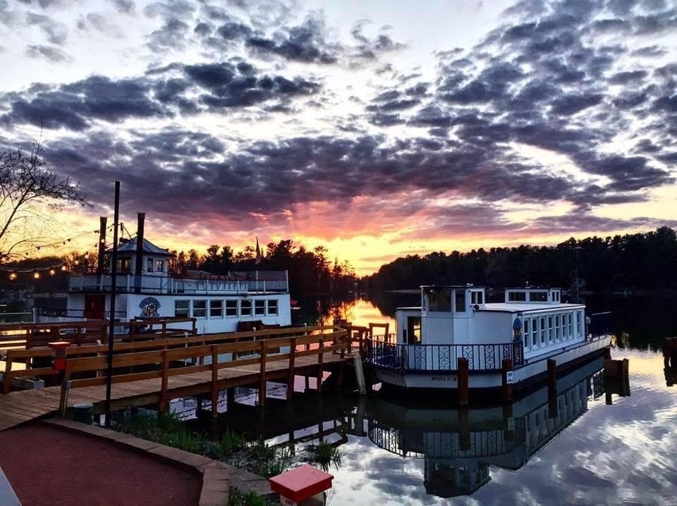 Riverboats at sunset on calm harbor dock for scenic waterfront cruises