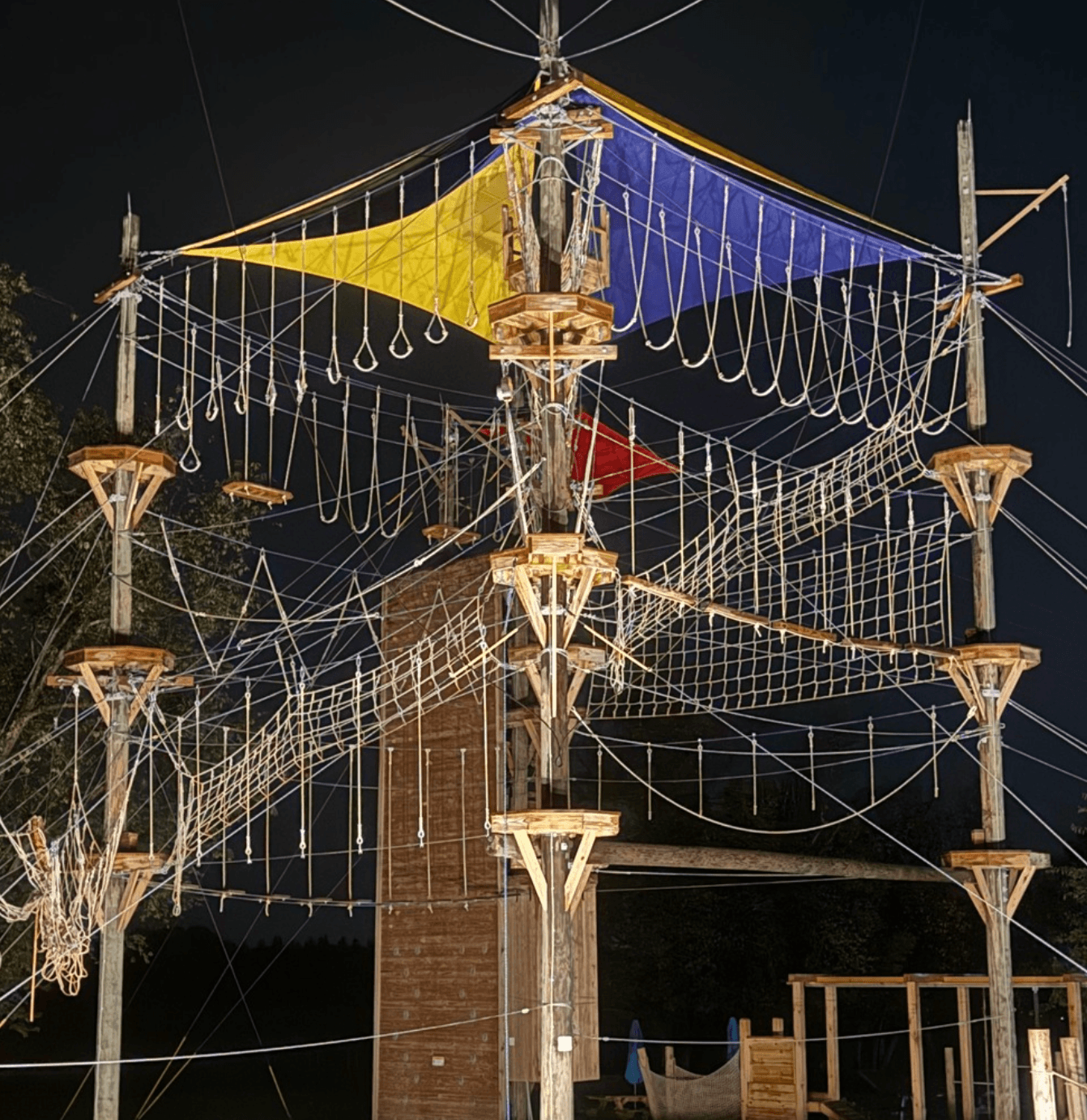Illuminated outdoor high ropes course at night, aerial adventure