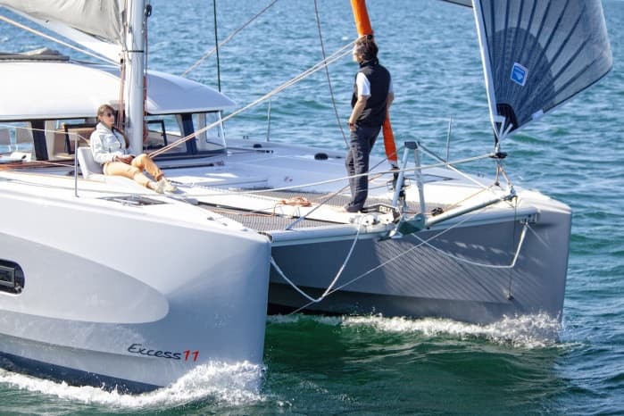 Catamaran bow with crew sailing on choppy sea