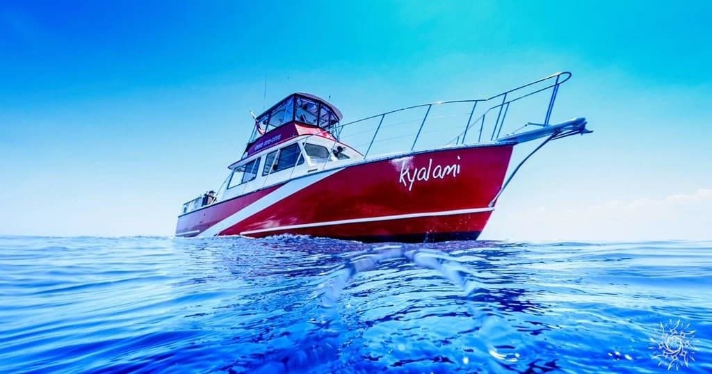 Red charter boat cruising tropical blue waters near Jupiter inlet