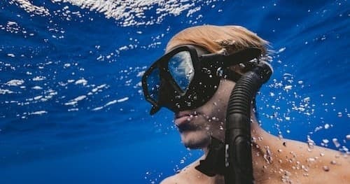 Snorkeler exploring clear blue waters with mask and snorkel