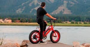 Rider on red fat-tire electric bike overlooking mountain lake