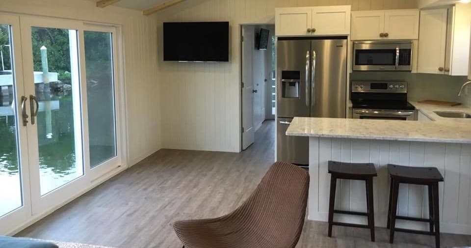 Open kitchen and seating on waterfront houseboat overlooking canal