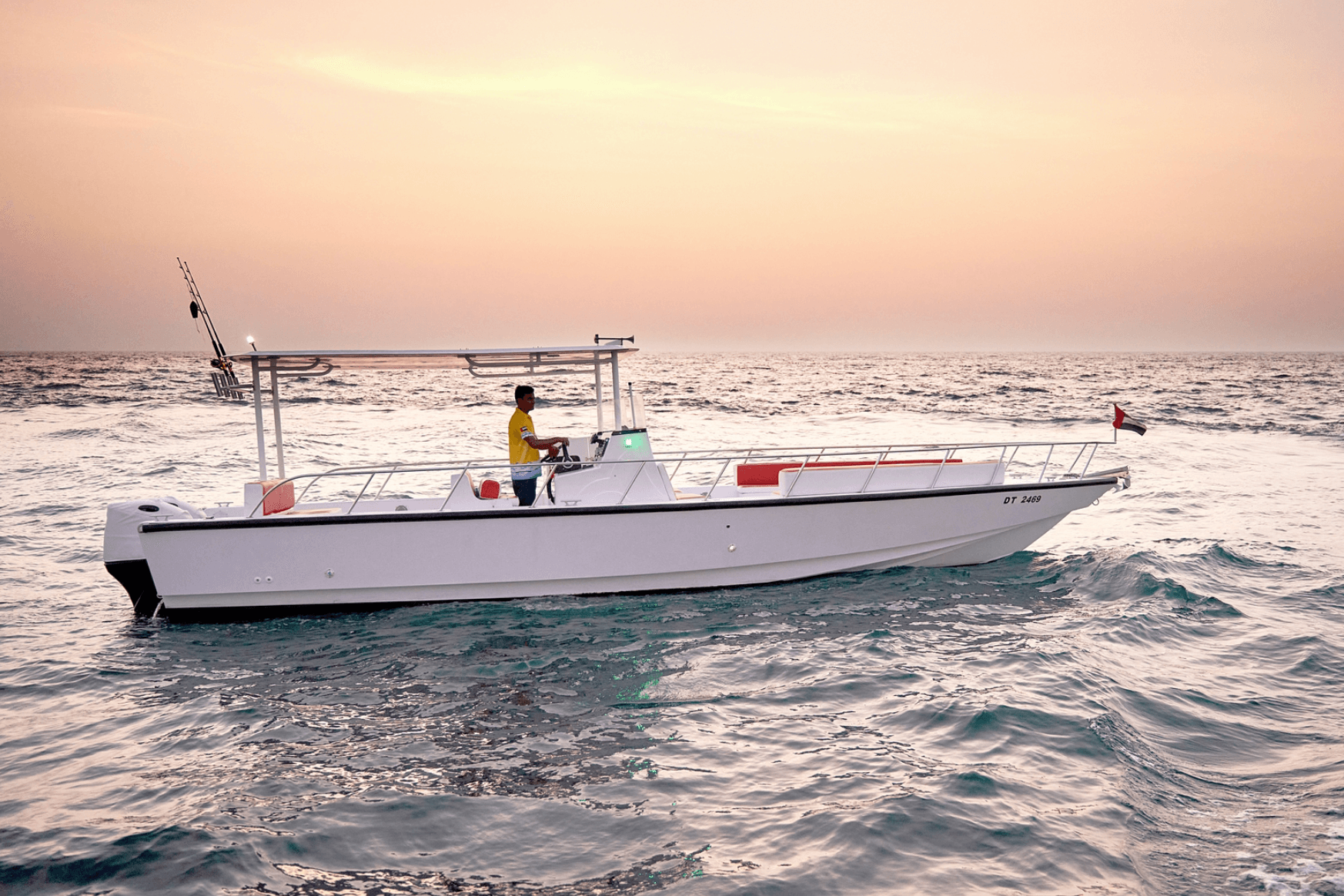 Fishing boat cruising at sunset on open sea near shore