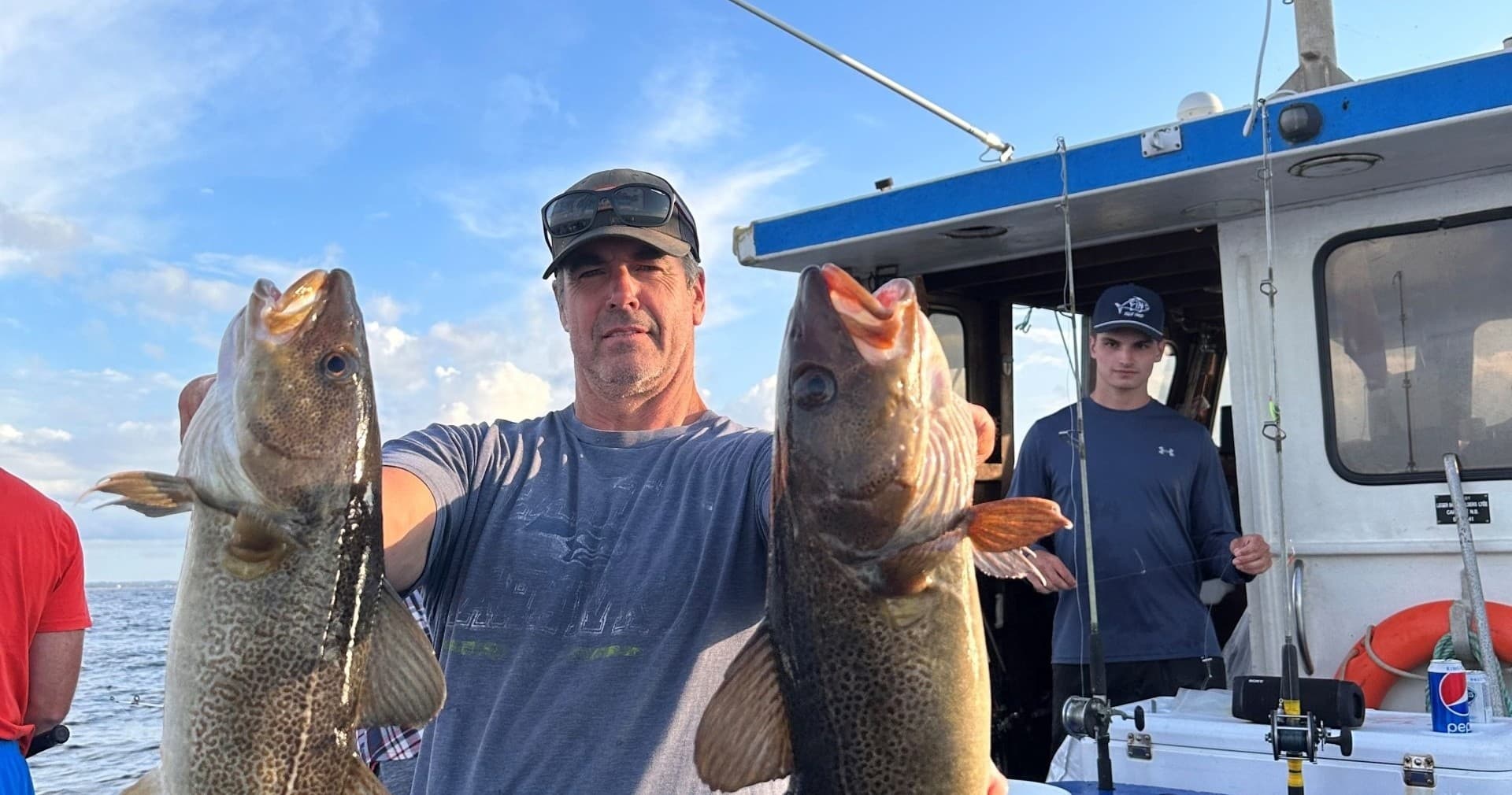 Fisherman holding twin cod caught on deep sea charter trip