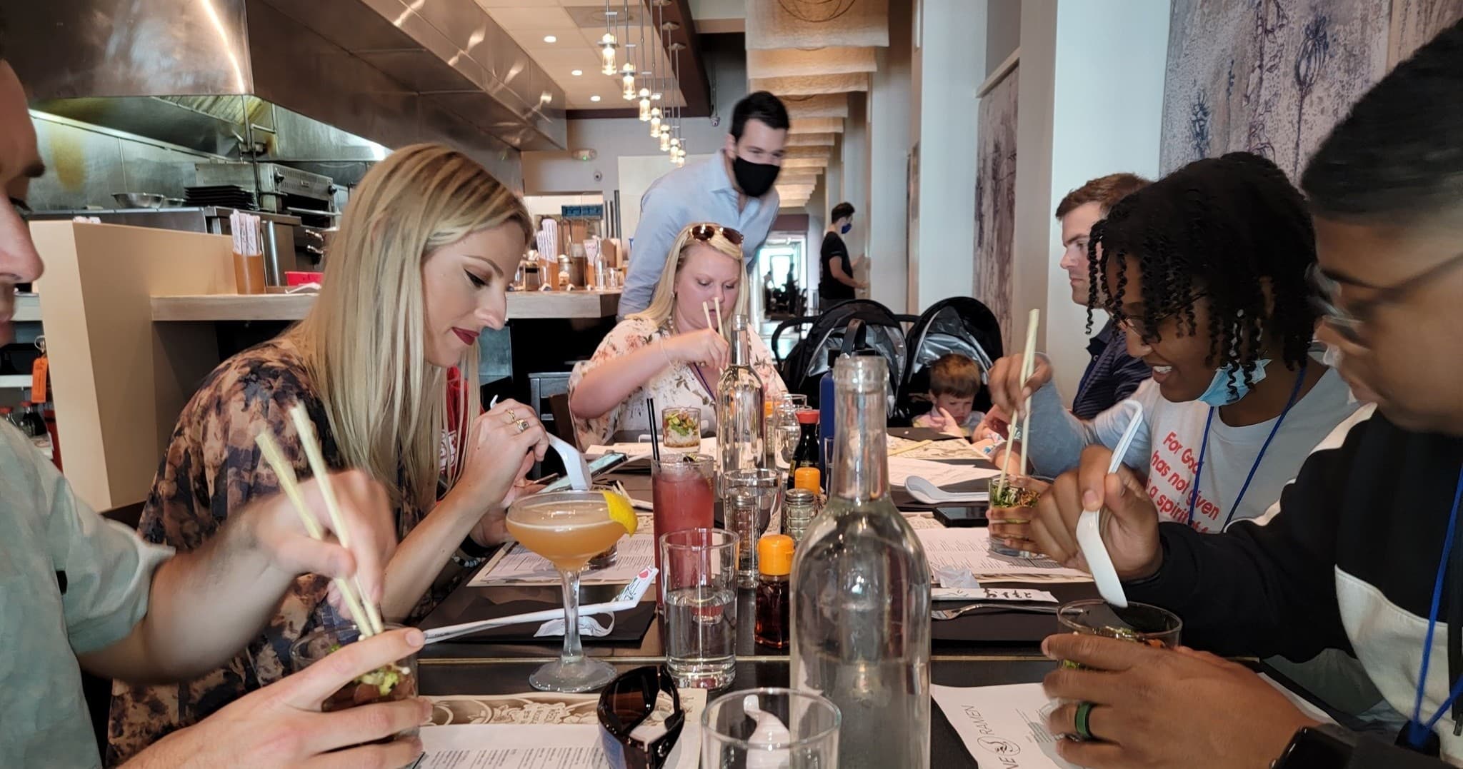 Group dining at indoor restaurant, tasting dishes at long table