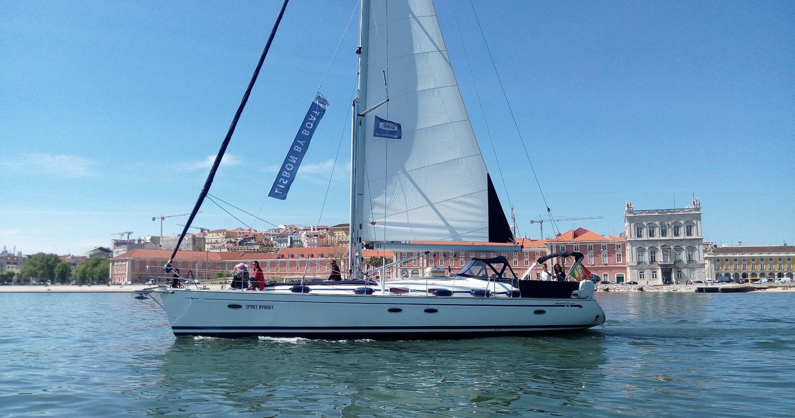 Daytime sailing tour in Lisbon harbor, yacht cruising by waterfront