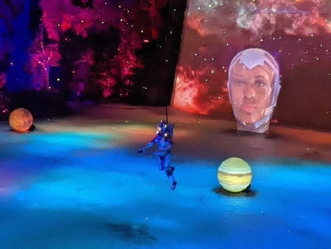 Indoor acrobatic show with cosmic set design in theater