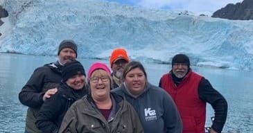 Anglers posing with glacier backdrop in Seward, Alaska