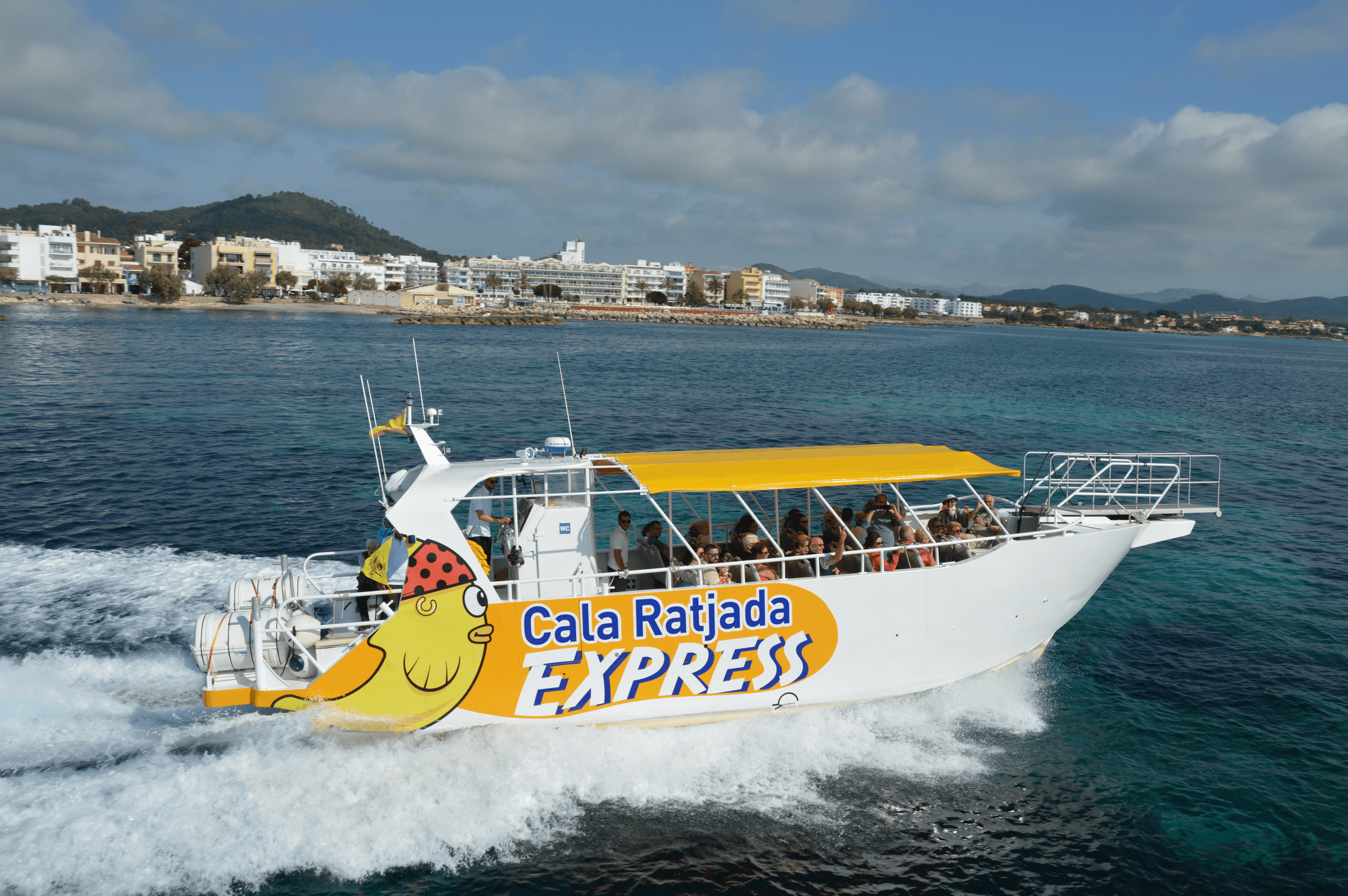 Passenger speedboat cruising along clear Mediterranean coastline