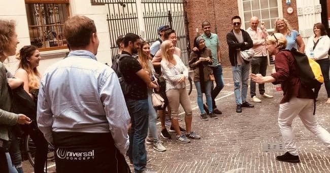 Energetic street performers and crowd during cobblestone comedy walk