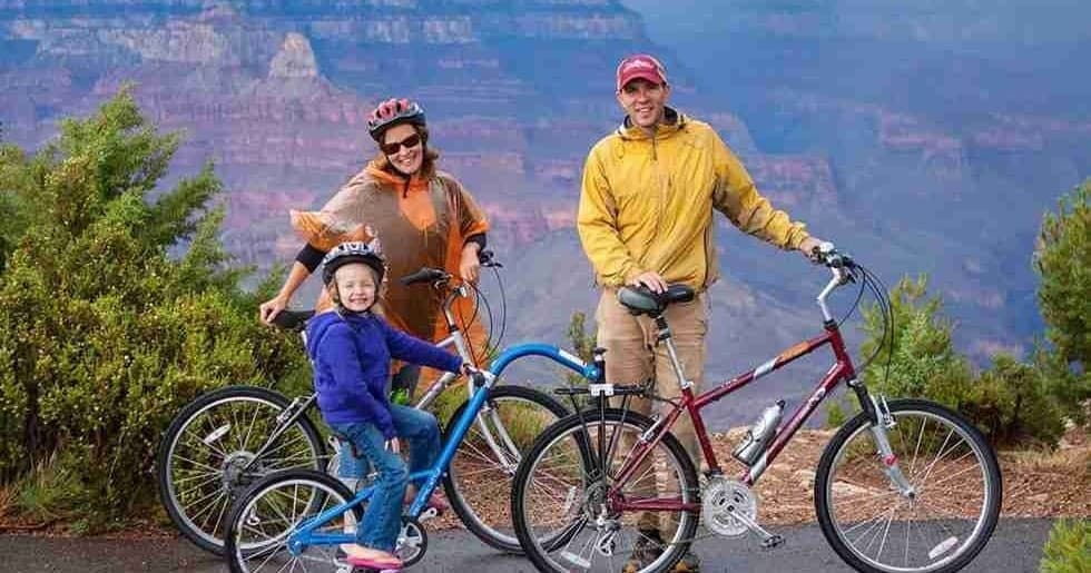 Family biking together on Grand Canyon rim trail with views