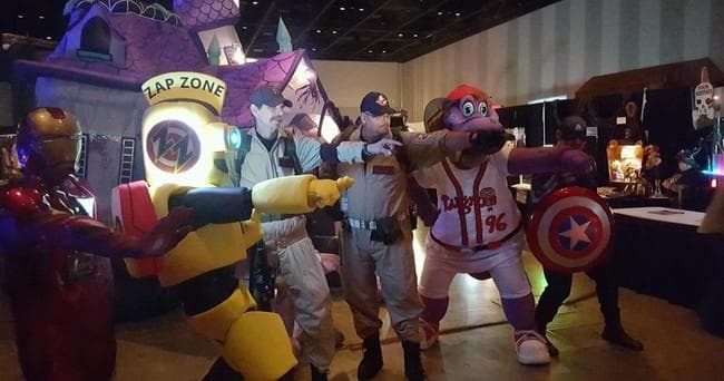 Costumed mascots posing with guests in indoor entertainment center