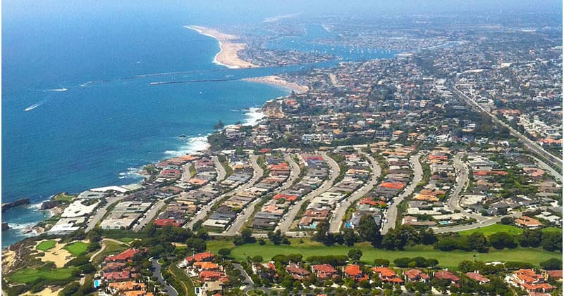 Aerial coastal neighborhood and shoreline scenic helicopter view