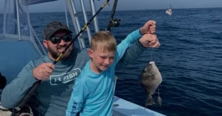 Father and son sportfishing on charter boat catching fish