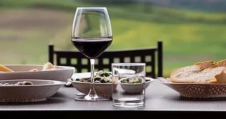 Wine glass and outdoor table with vineyard view, tasting setup