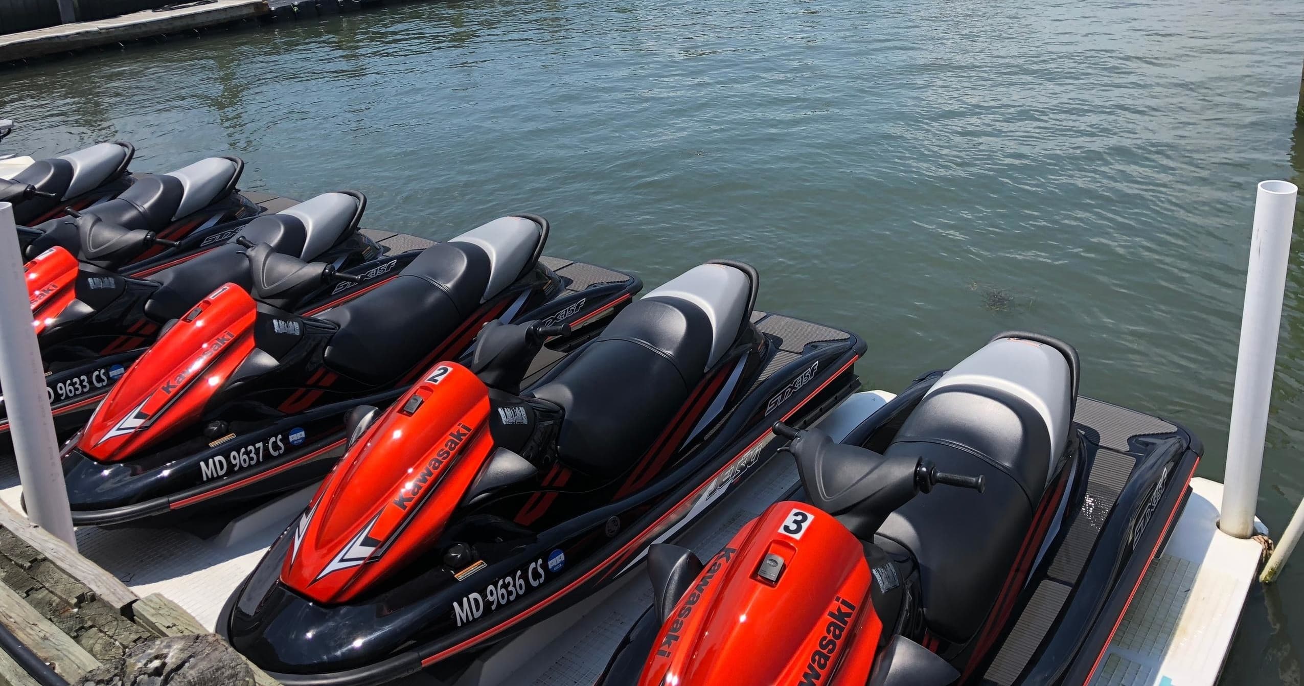 Stacked rental jet skis docked at marina ready for tours