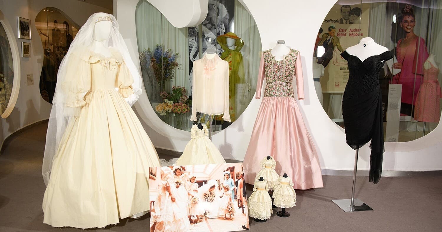 Vintage wedding gowns displayed in museum exhibit window