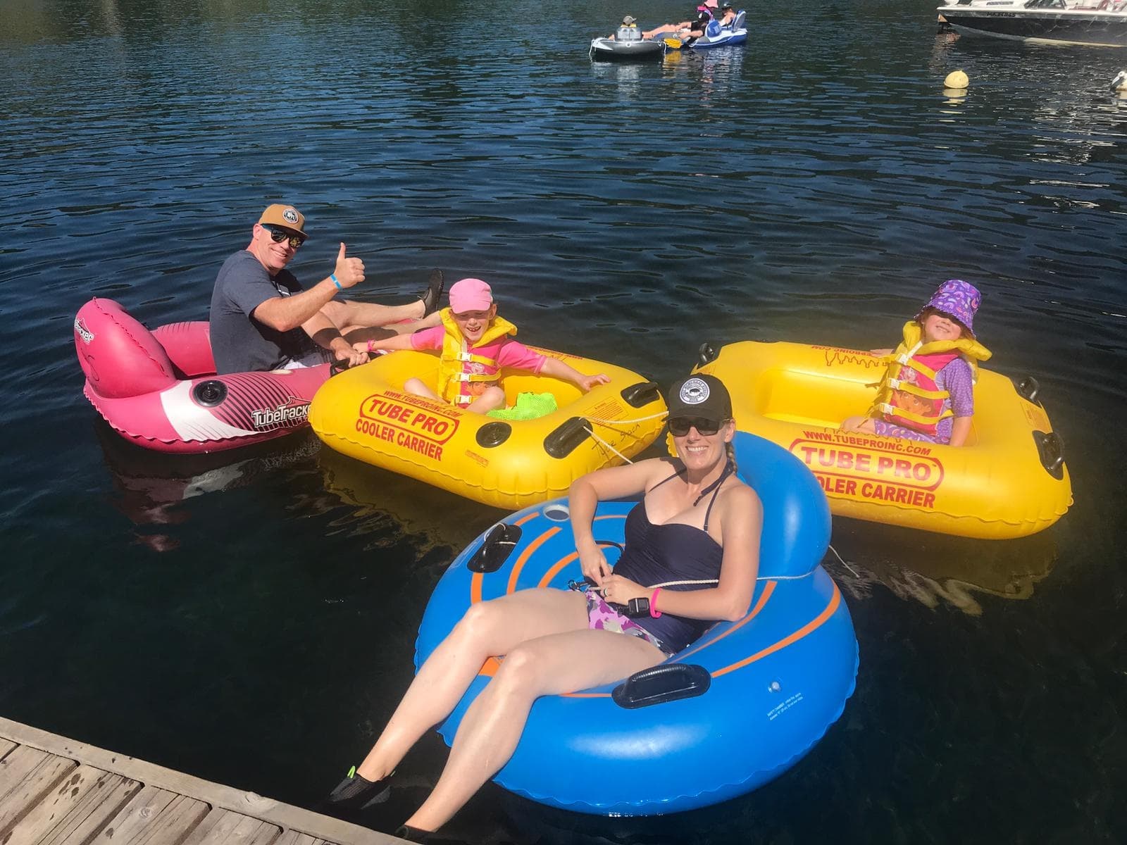 Friends relaxing on bright rental tubes at Lake Cowichan dock