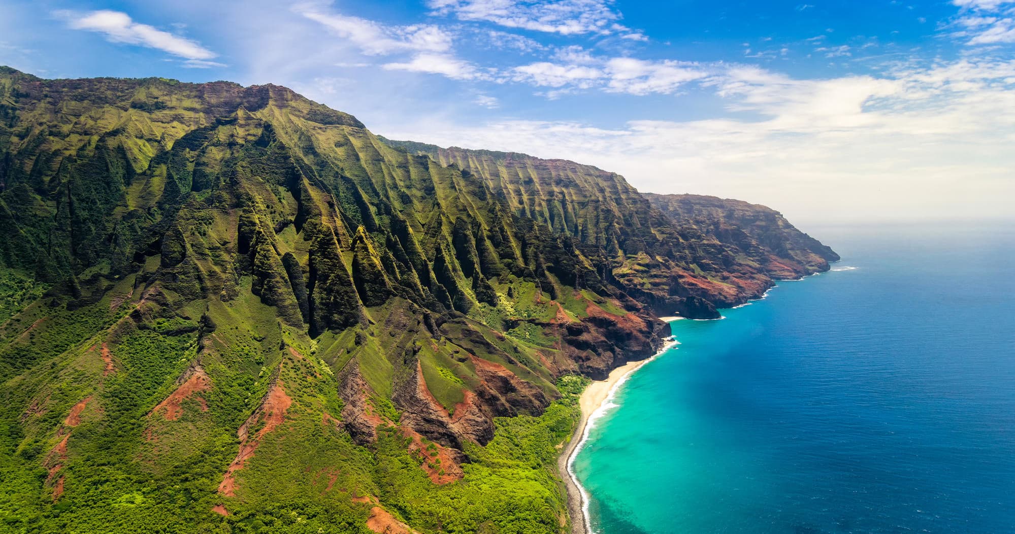 Aerial helicopter view of Na Pali Coast cliffs and turquoise sea