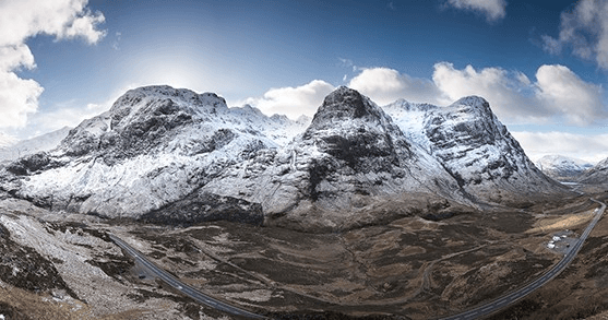 Snow-capped mountain range with dramatic clouds, alpine hiking vista