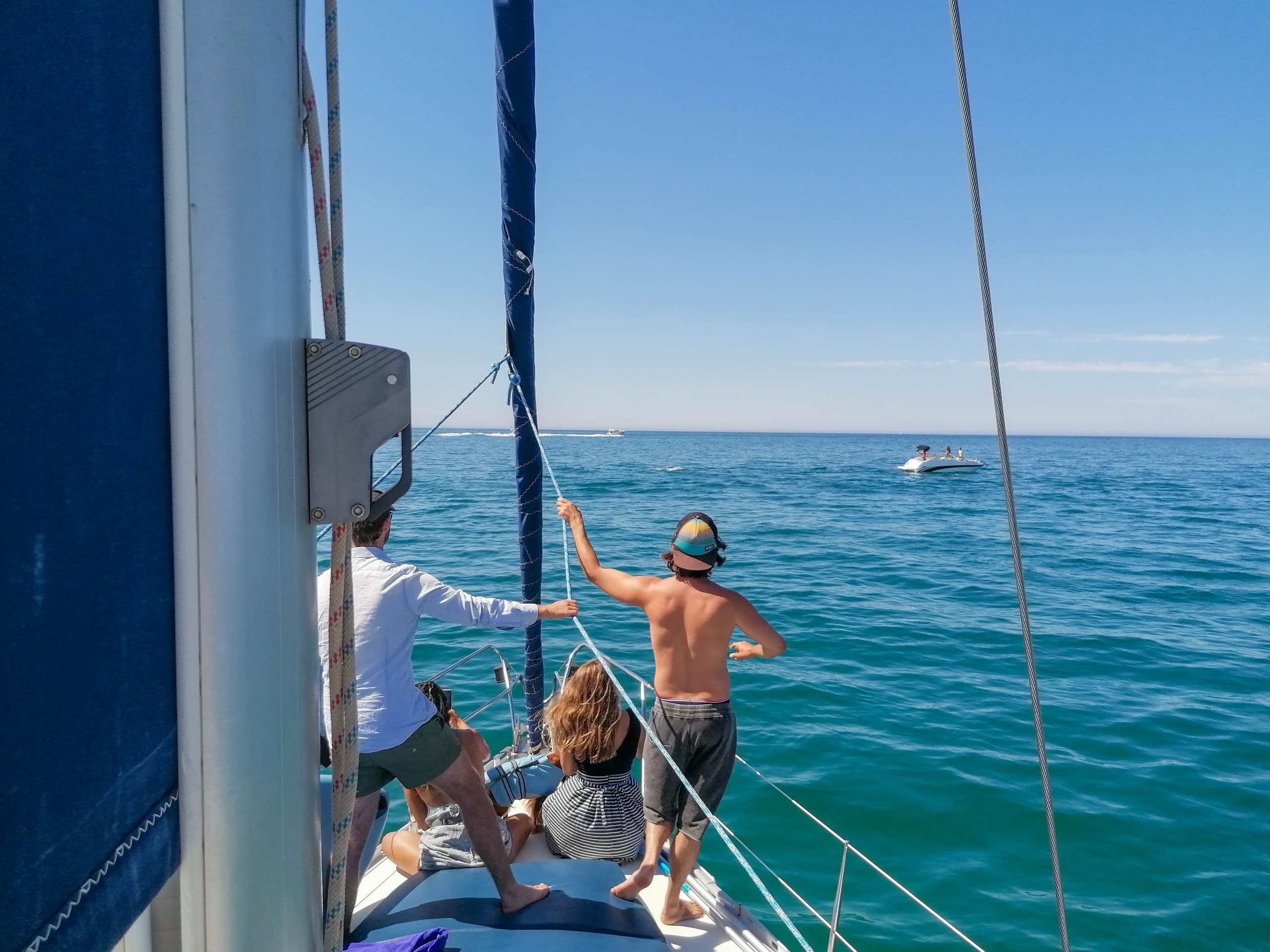 People sailing on open Atlantic waters from a yacht bow