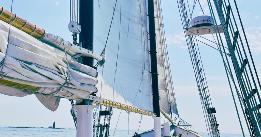 Sailboat rigging and sails on coastal waters, scenic day sail