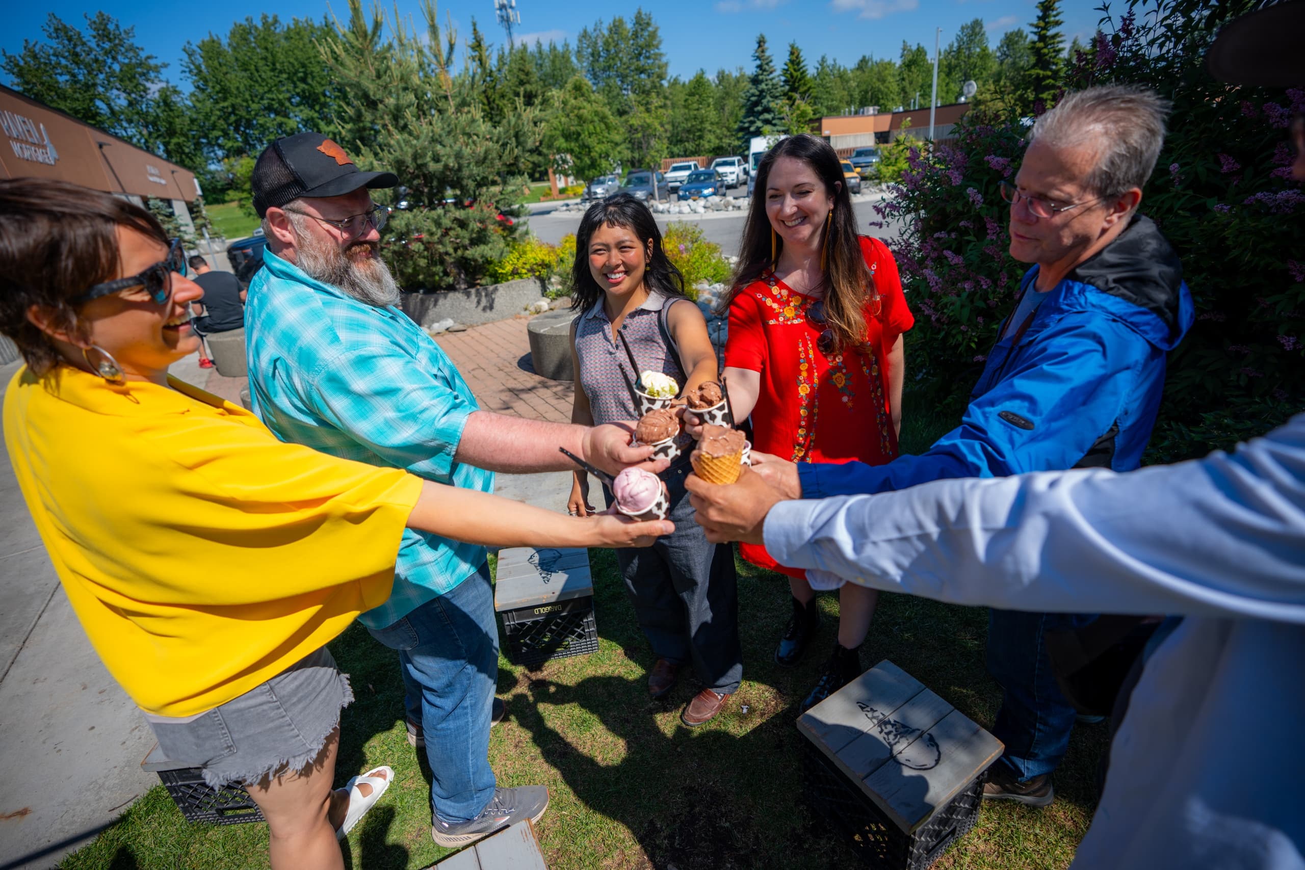 People toasting at an outdoor summer festival in a park