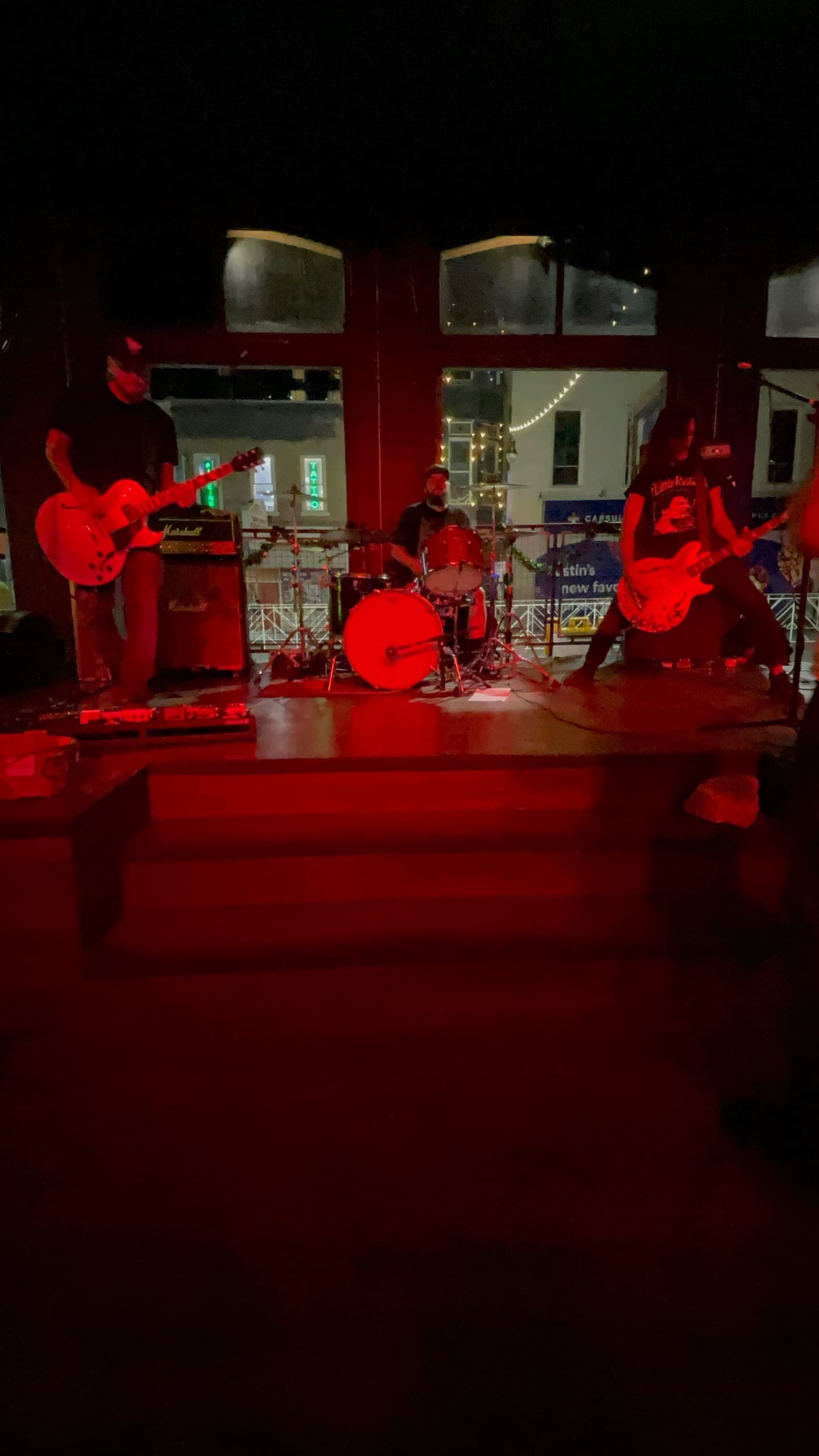 Live band performing on red-lit indoor stage at venue