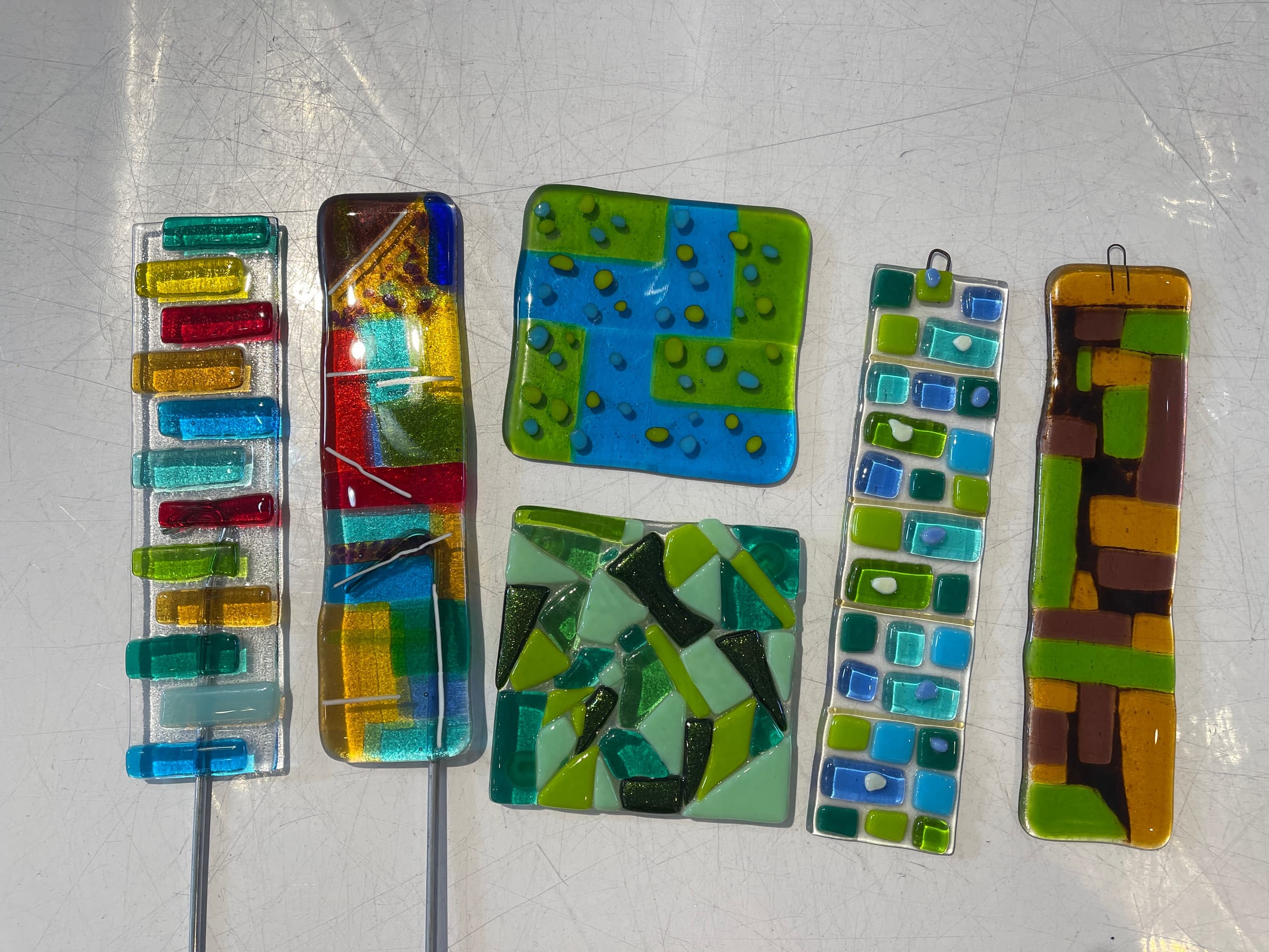 Assorted fused glass garden stakes and decorative panels display