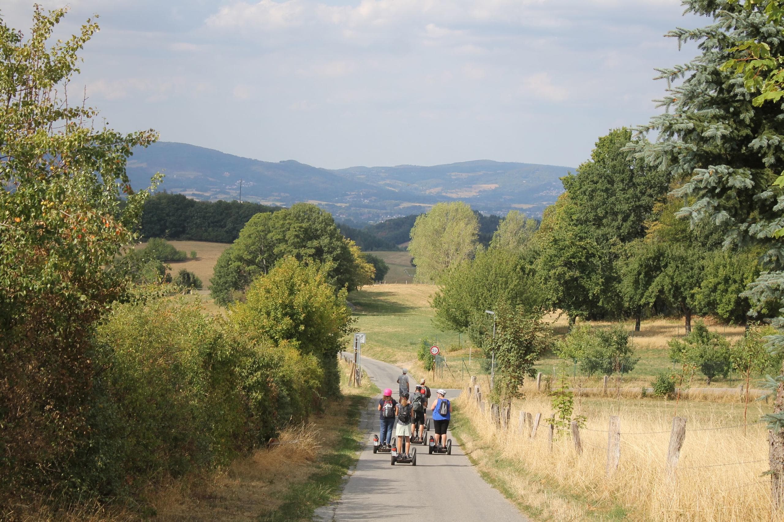 Segway tour riders on rural country road with rolling hills