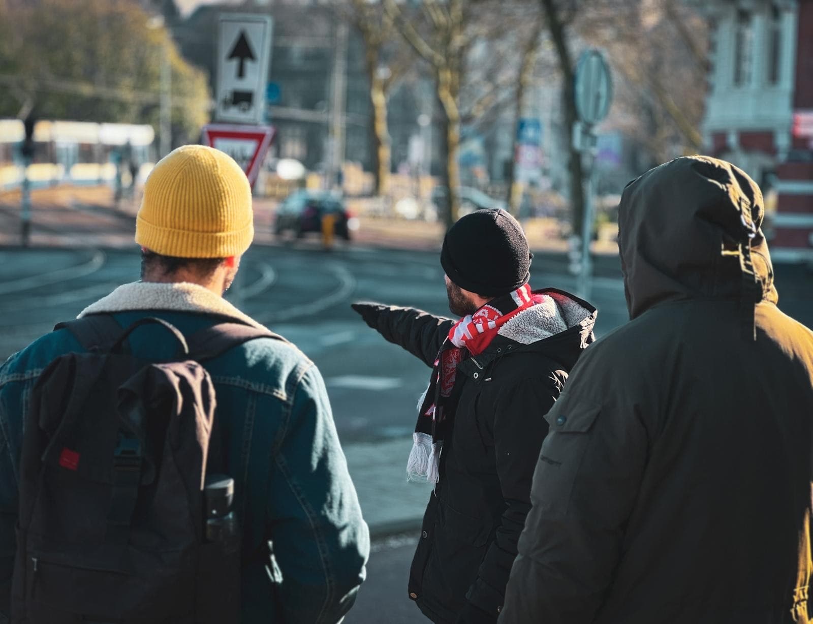 Urban cyclists on city street in winter pointing the route ahead