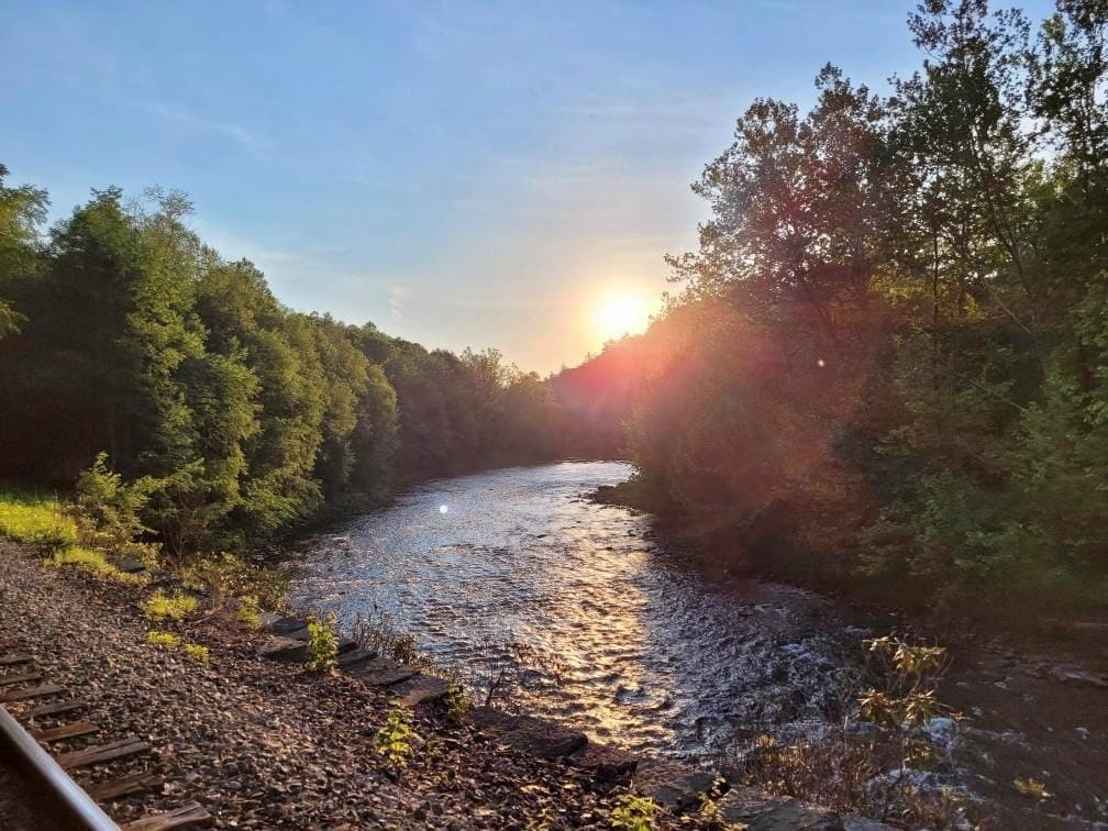 Sunset over forested river valley for scenic riverside views