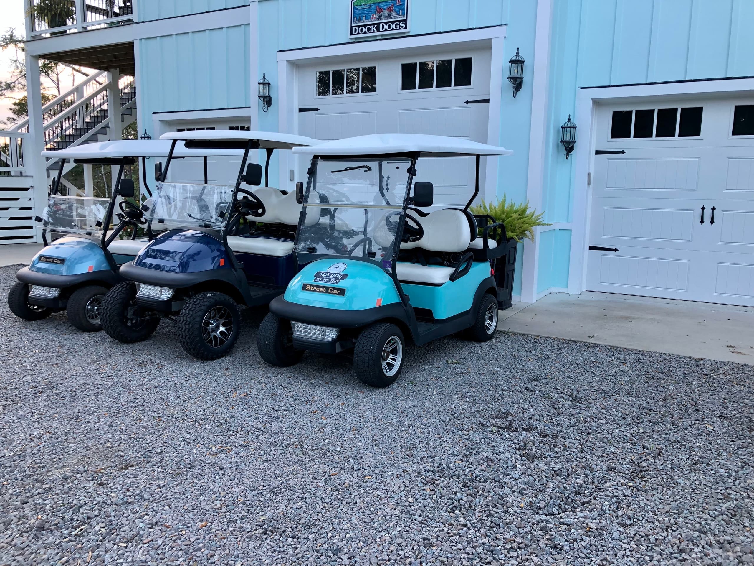 Three rental golf carts lined up outside beach garage