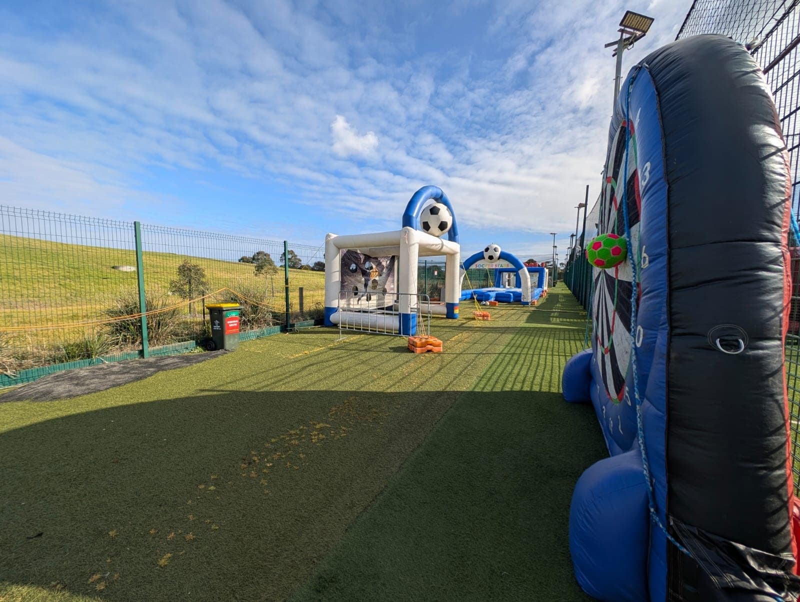 Outdoor inflatable obstacle course on turf under blue sky field