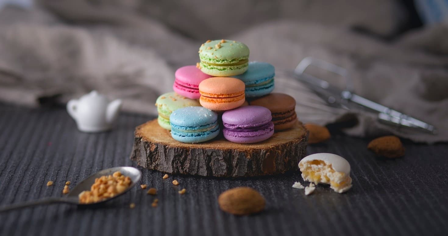 Colorful macarons stacked on wood in styled dessert photoshoot