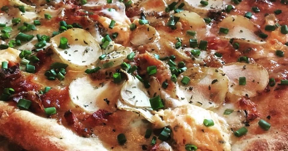 Wood-fired pizza close-up on St. Pete food tour, fresh toppings