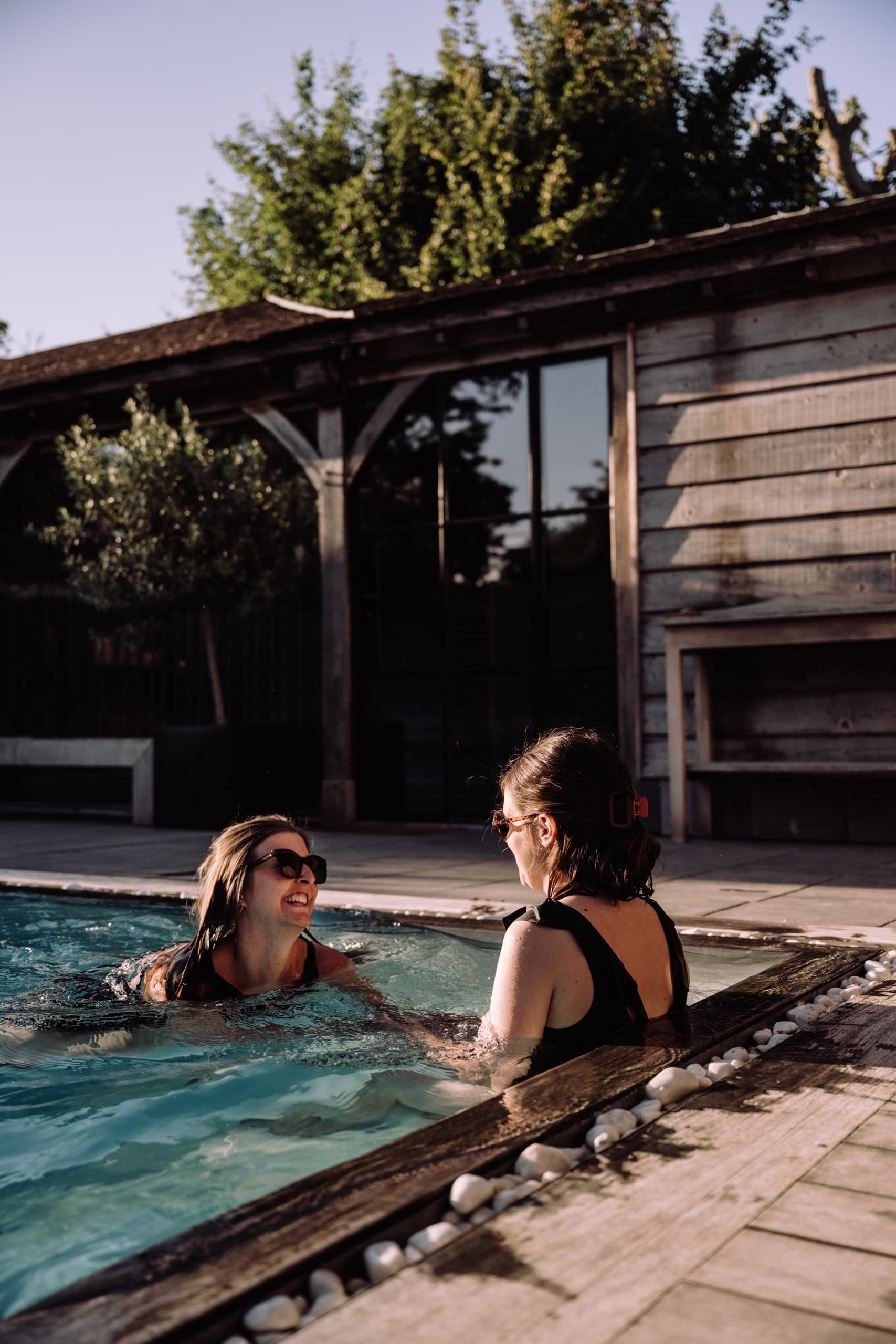 Two women talking and swimming in an outdoor resort pool