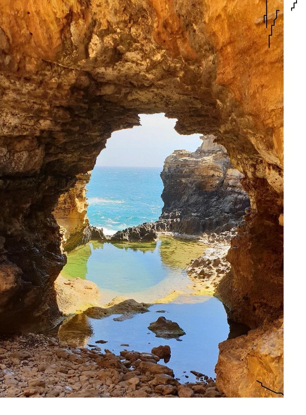 Sea arch cave framing ocean view on rugged coastal cliffs