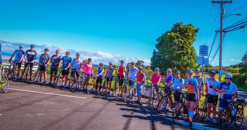 Large group of cyclists on scenic Maui coastal road tour